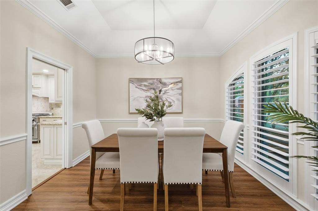 Formal dining with a tray ceiling, designer chandelier and a pocket door to the kitchen for easy hosting.
