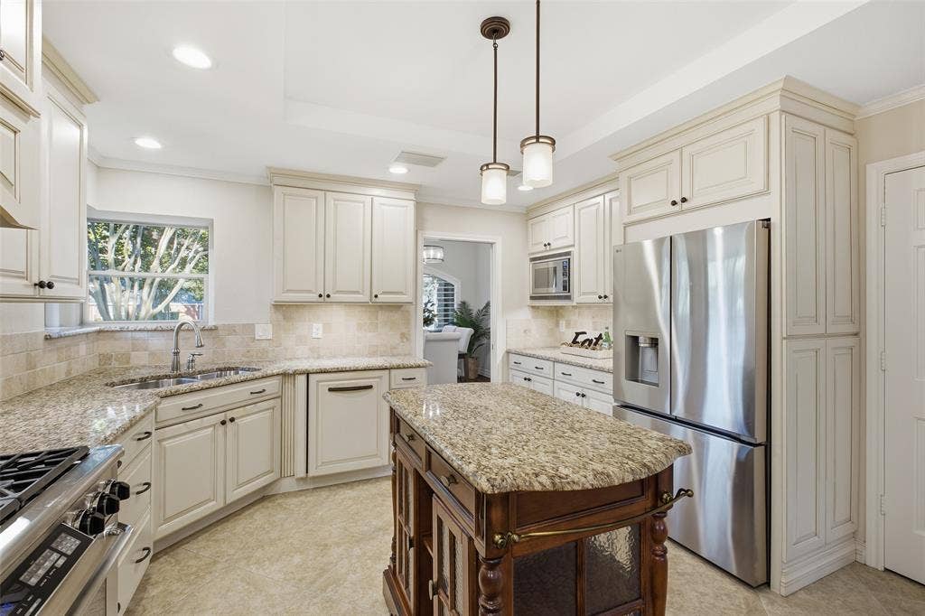 Cook with a view: sunny corner window over the sink, granite counters, built-in microwave and abundant cabinetry.
