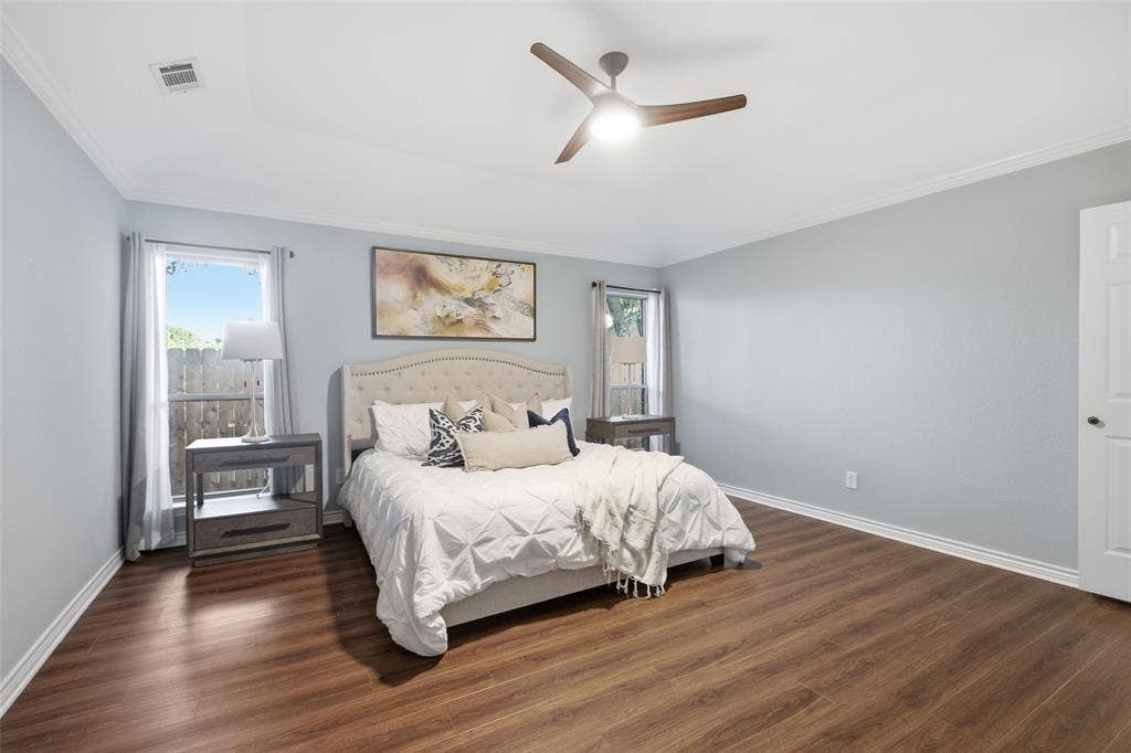 Primary suite with vaulted ceiling, ceiling fan and crown molding: a serene place to unwind.