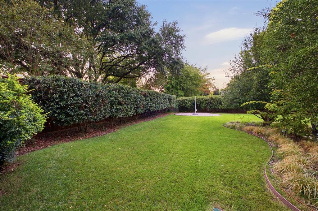 Wide-open, hedge-lined backyard with room for play, pets and gatherings.