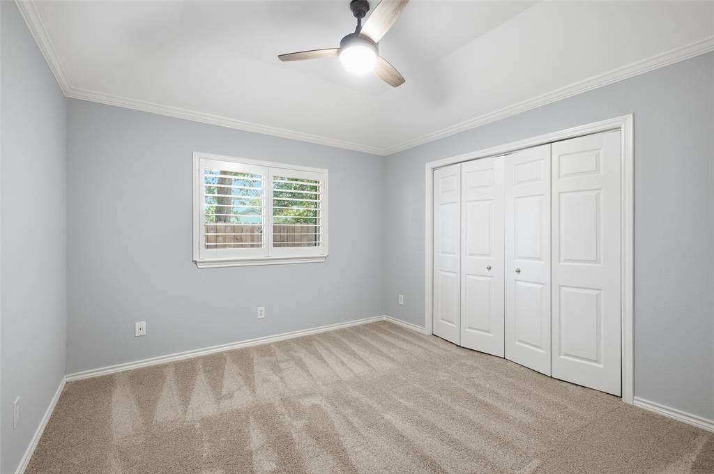 Calm blue walls, ceiling fan and a generous closet make this bedroom a restful retreat.