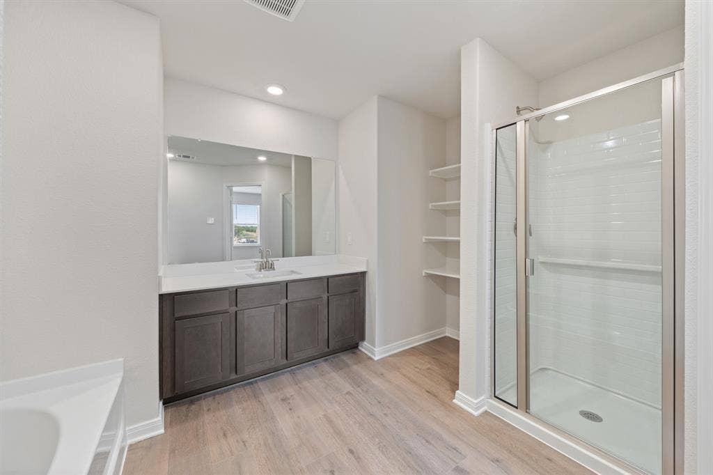 1534 William Wallace Street, Crandall, TX 75114 Bathroom featuring vanity, wood finished floors, a stall shower, and recessed lighting