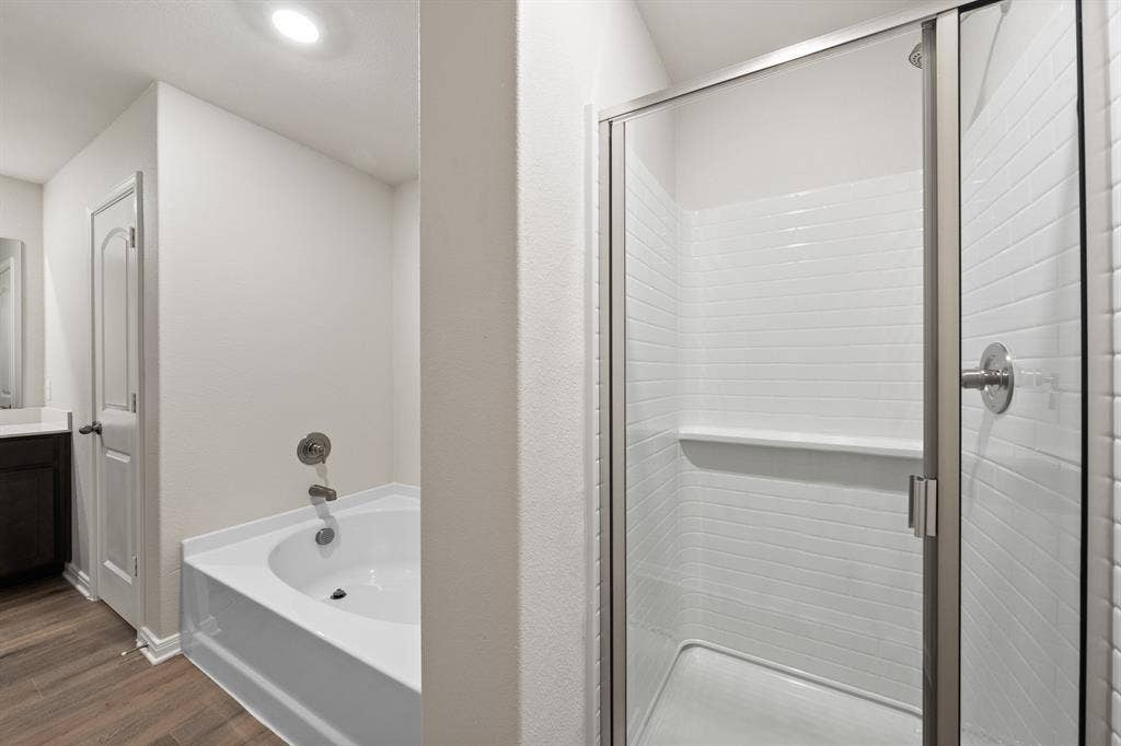 2037 Braveheart Drive, Crandall, TX 75114 Bathroom featuring a bath, a shower stall, wood finished floors, and vanity