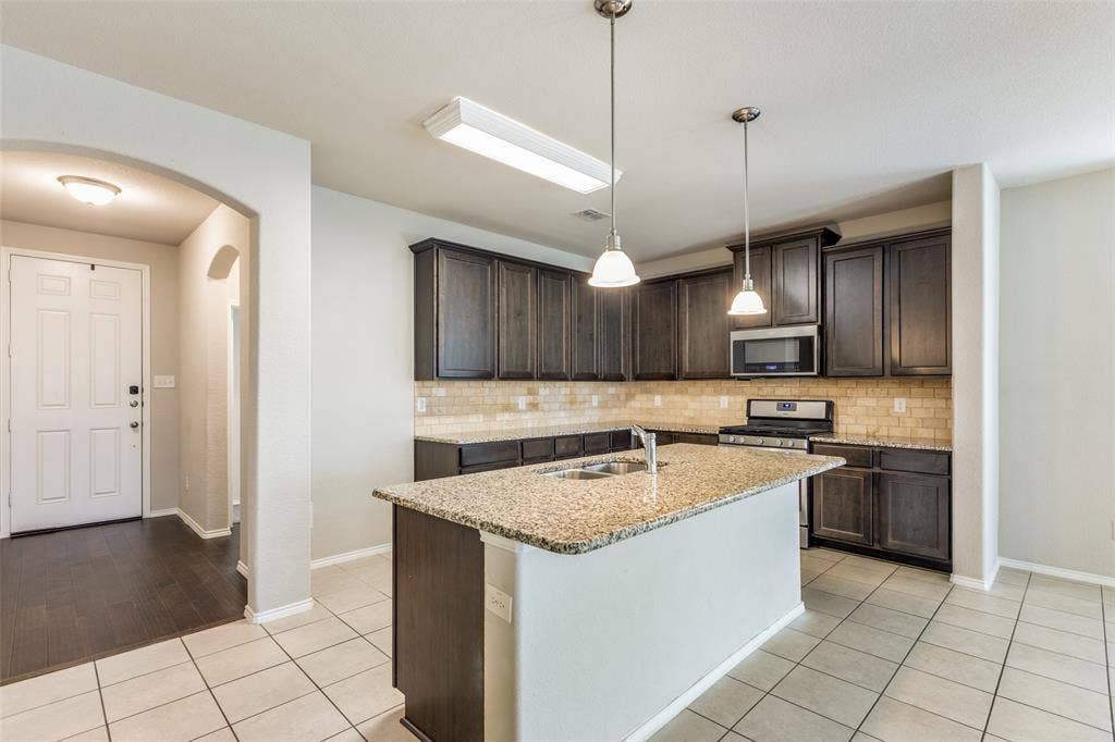 Kitchen with a central island featuring a stainless-steel sink and a gooseneck faucet
