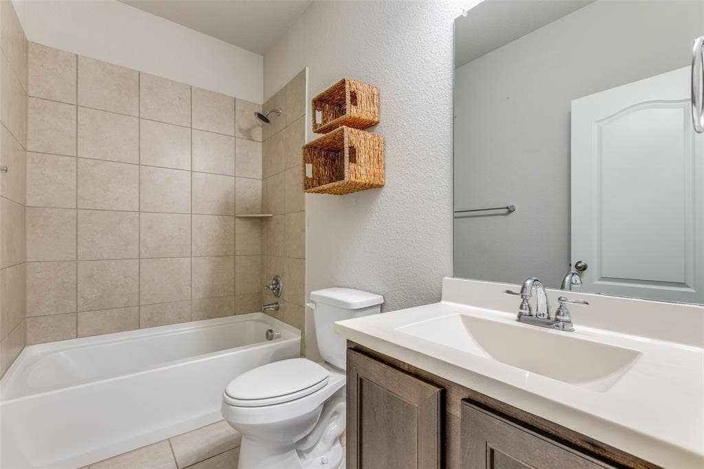 Full bathroom with a tub/shower combination, tiled walls, and a single vanity with an integrated sink