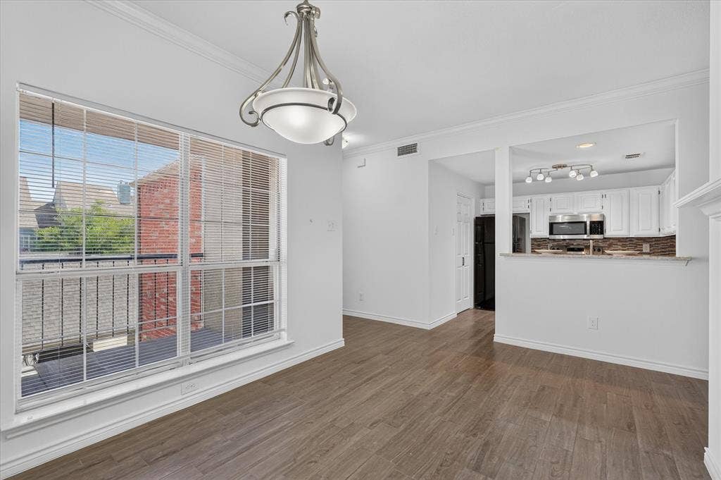 12660 Hillcrest Road, #5204, Dallas, TX 75230 Spacious room featuring wood-finish flooring, a large window with blinds, and a decorative ceiling light fixture