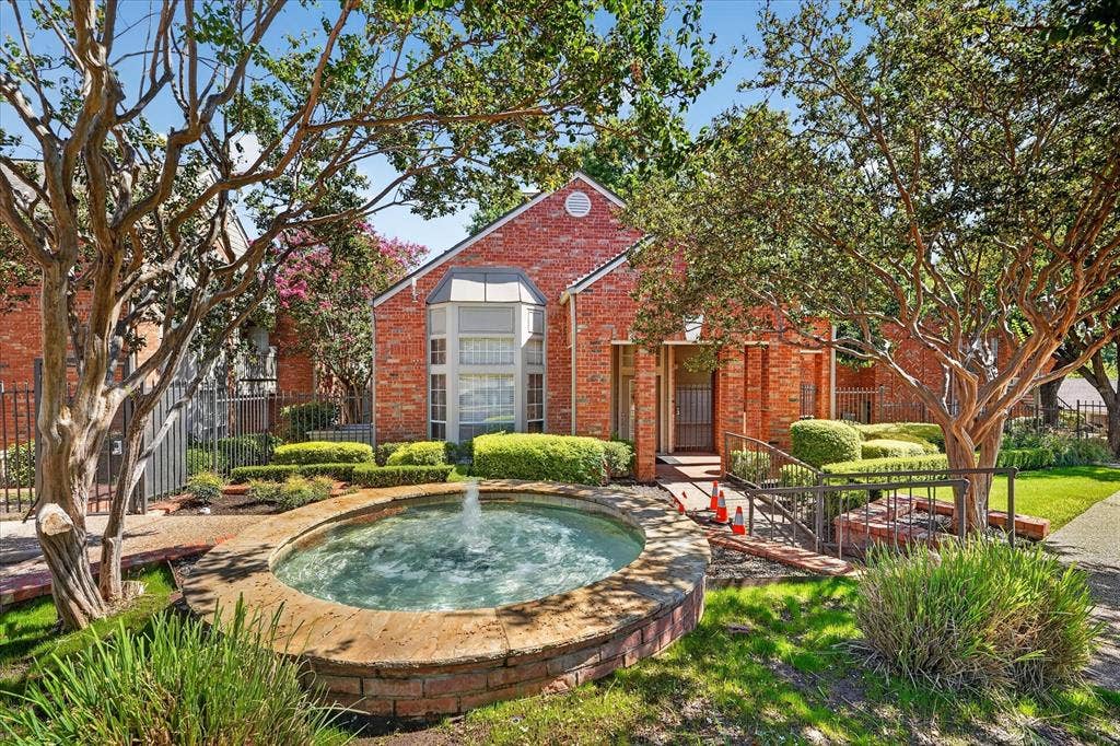 12660 Hillcrest Road, #5204, Dallas, TX 75230 Red brick exterior with a prominent arched window and a decorative fountain