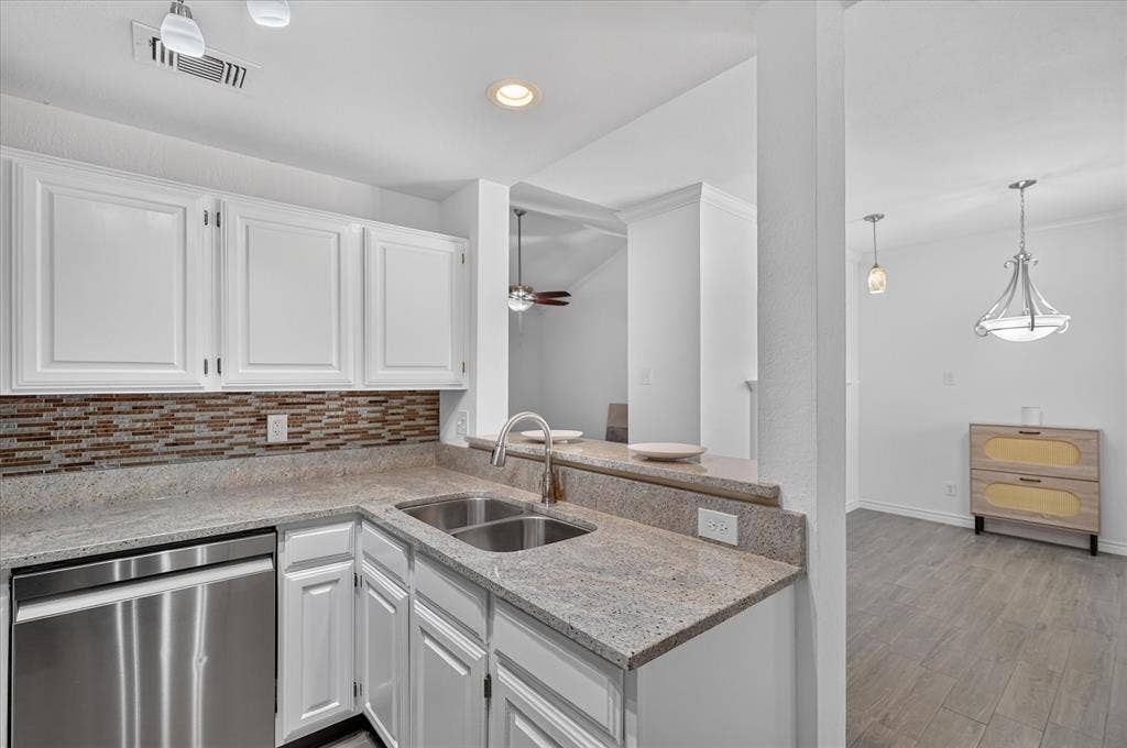 12660 Hillcrest Road, #5204, Dallas, TX 75230 Kitchen featuring white cabinetry, stone countertops, mosaic tile backsplash, stainless steel dishwasher, and a double basin sink with a gooseneck faucet