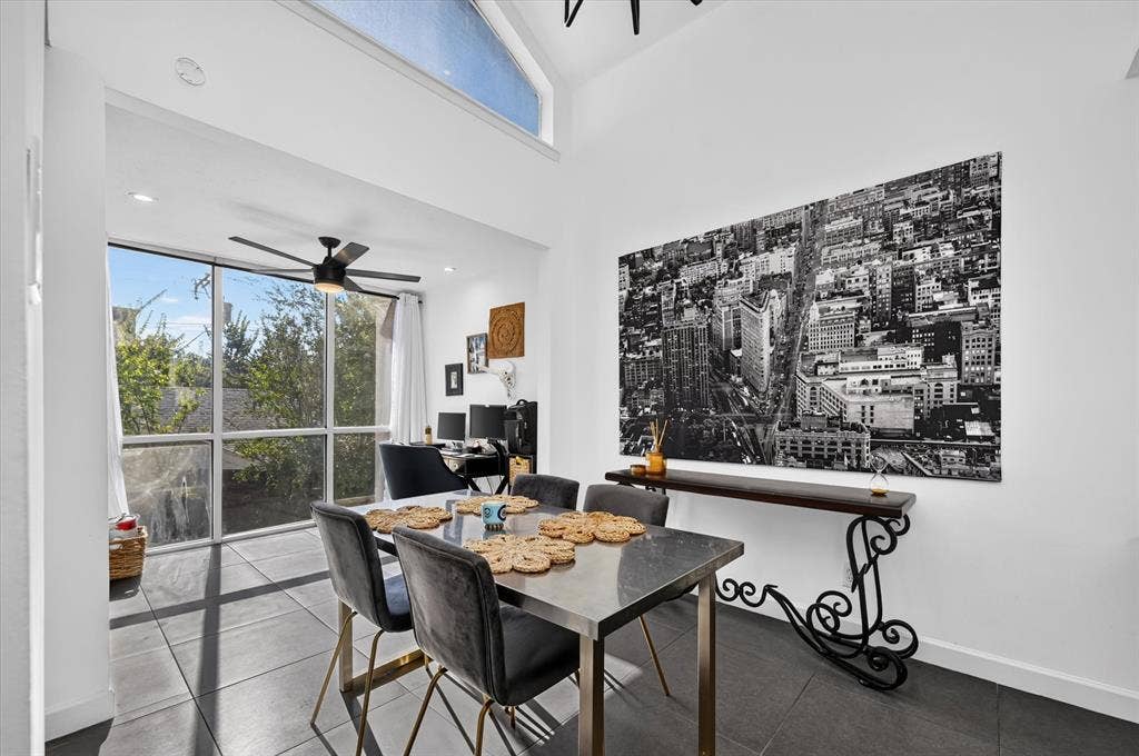 Vaulted ceiling, full-height windows, transom window, recessed lighting, and dark tile flooring