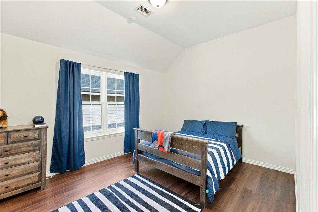 Vaulted ceiling, recessed lighting, wood-finish flooring, and a double-hung window