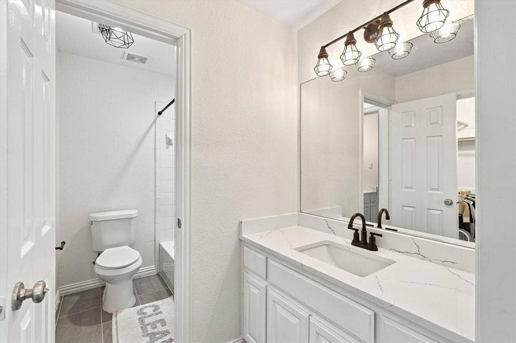 Vanity with an integrated sink, a white countertop, and white cabinetry
