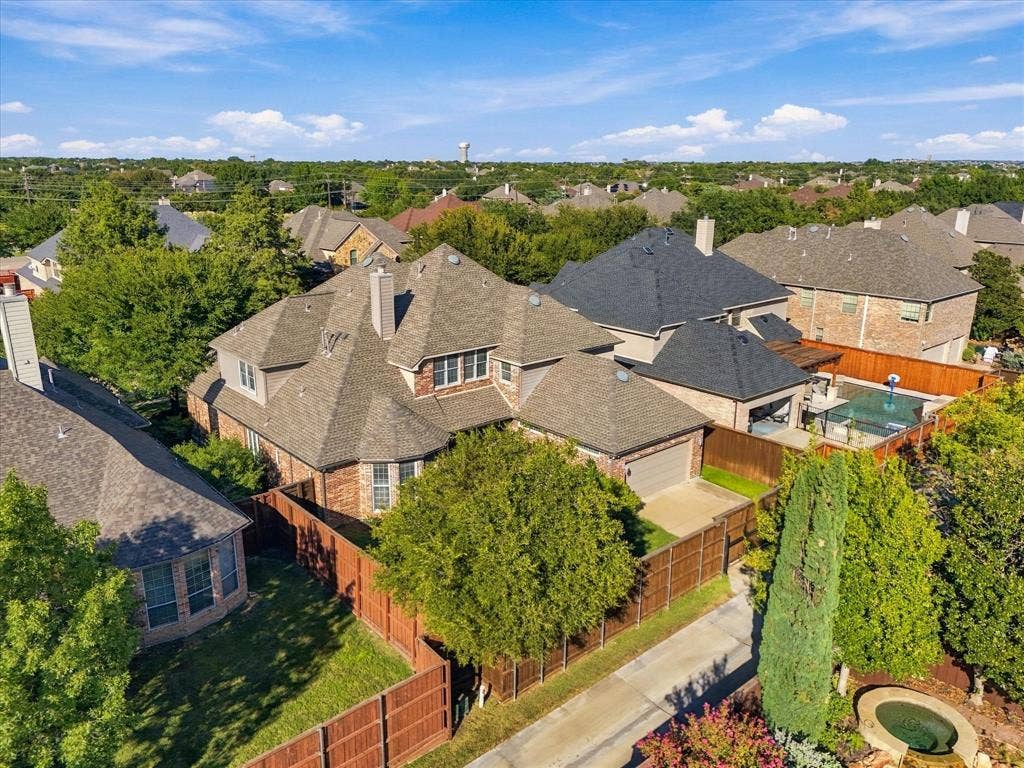 Brick exterior with multiple gables, attached garage, private backyard with a pool, and mature perimeter trees