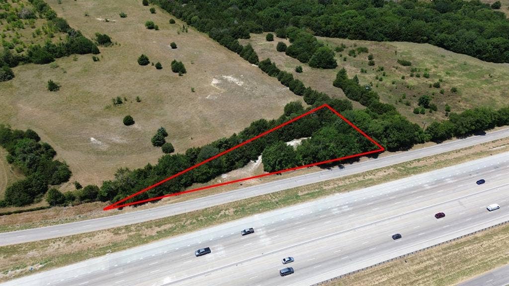 TBD S Interstate 35, Waxahachie, TX 75165 Expansive land parcel featuring natural tree coverage and direct highway frontage