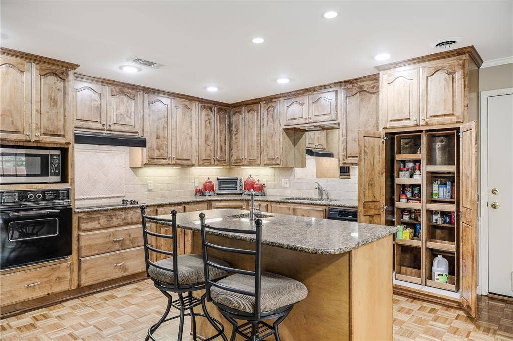 Views of the pull out custom pantry and custom 42 inch cabinets with under cabinet lighting and canned lighting in the ceiling!  Very comfortable entertaining with plenty of cabinets and storage space!