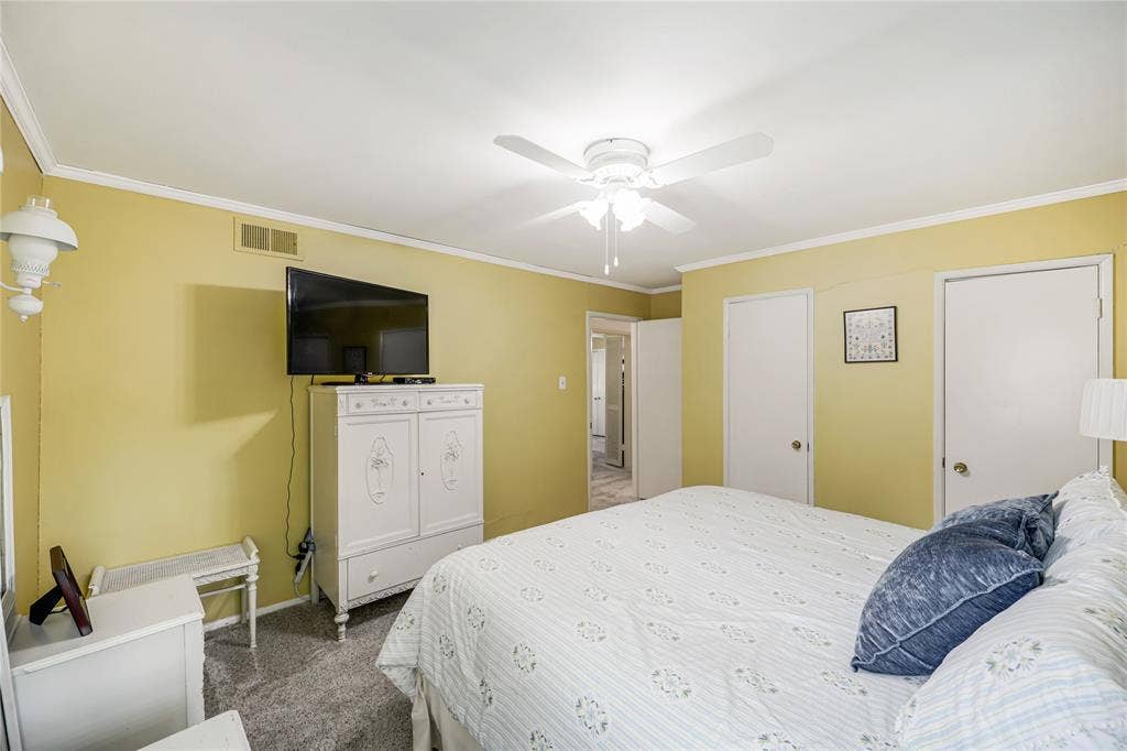 Plenty of storage this cheerful  bedoom has a ceiling fan and also two closets!