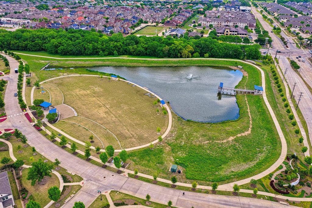 Expansive green spaces featuring a central pond with a fountain feature
