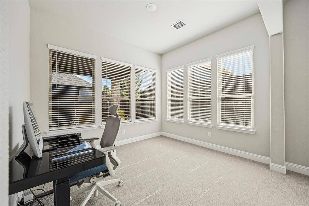 Neutral color palette with recessed lighting, multiple windows, and light-colored carpeting