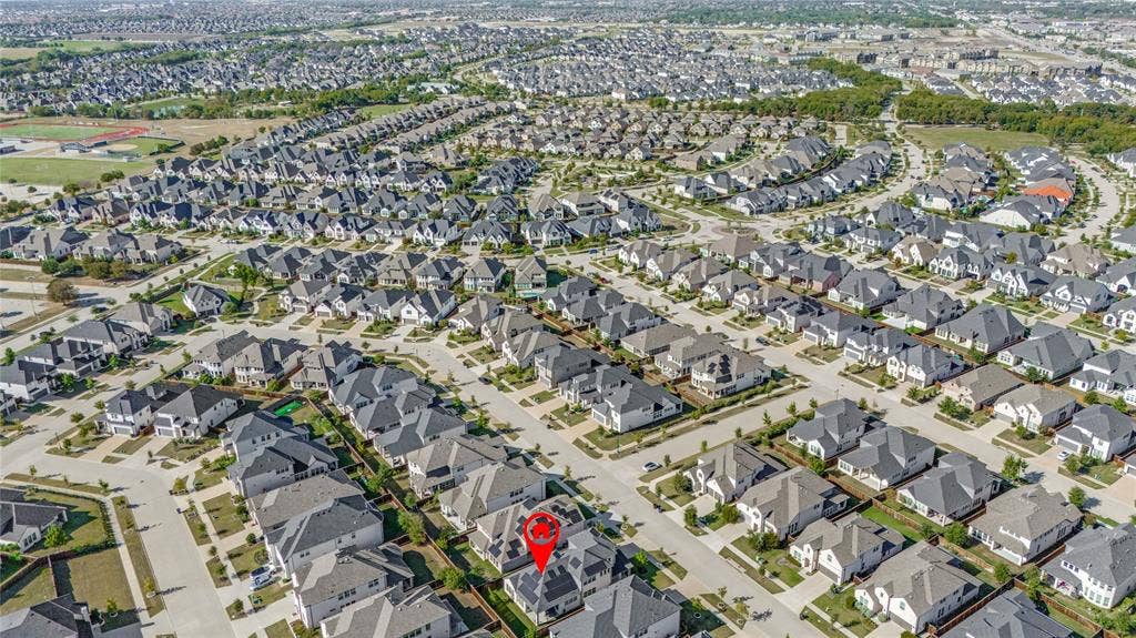 Expansive residential development featuring numerous single-story and two-story homes with dark-toned roofing and light-colored exteriors