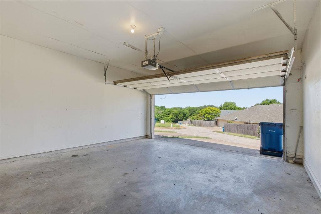 Attached garage with a concrete floor and an automatic overhead door opener