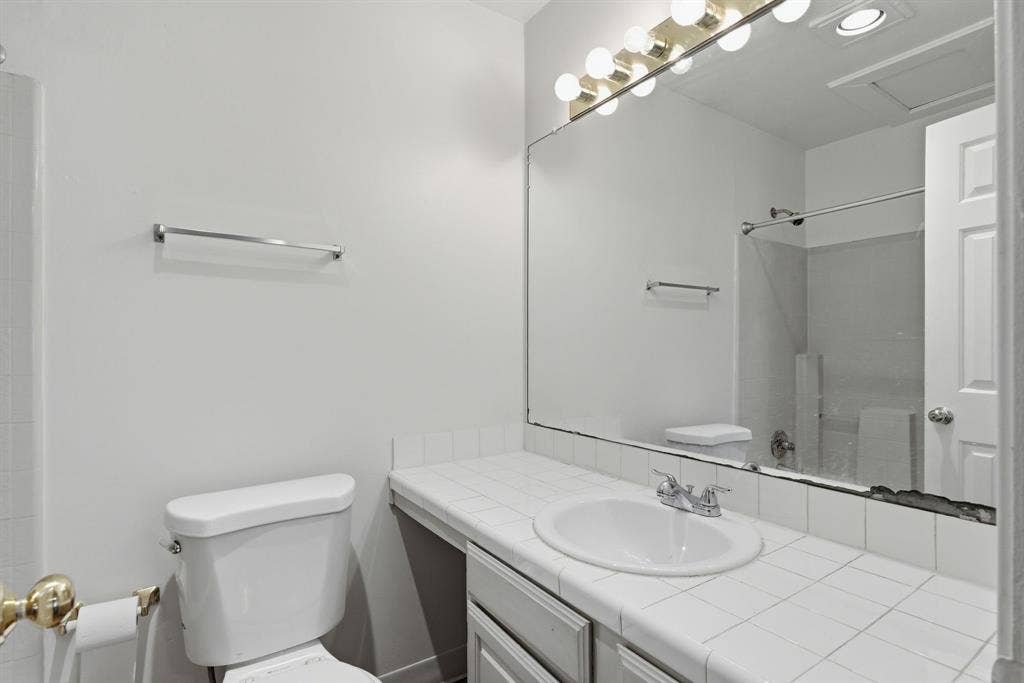 Integrated vanity with a white tile countertop, drop-in sink, and chrome-finish faucet