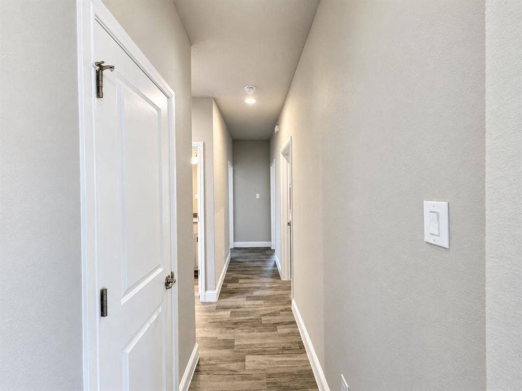 Hallway featuring wood-finish flooring, recessed lighting, and neutral-toned walls