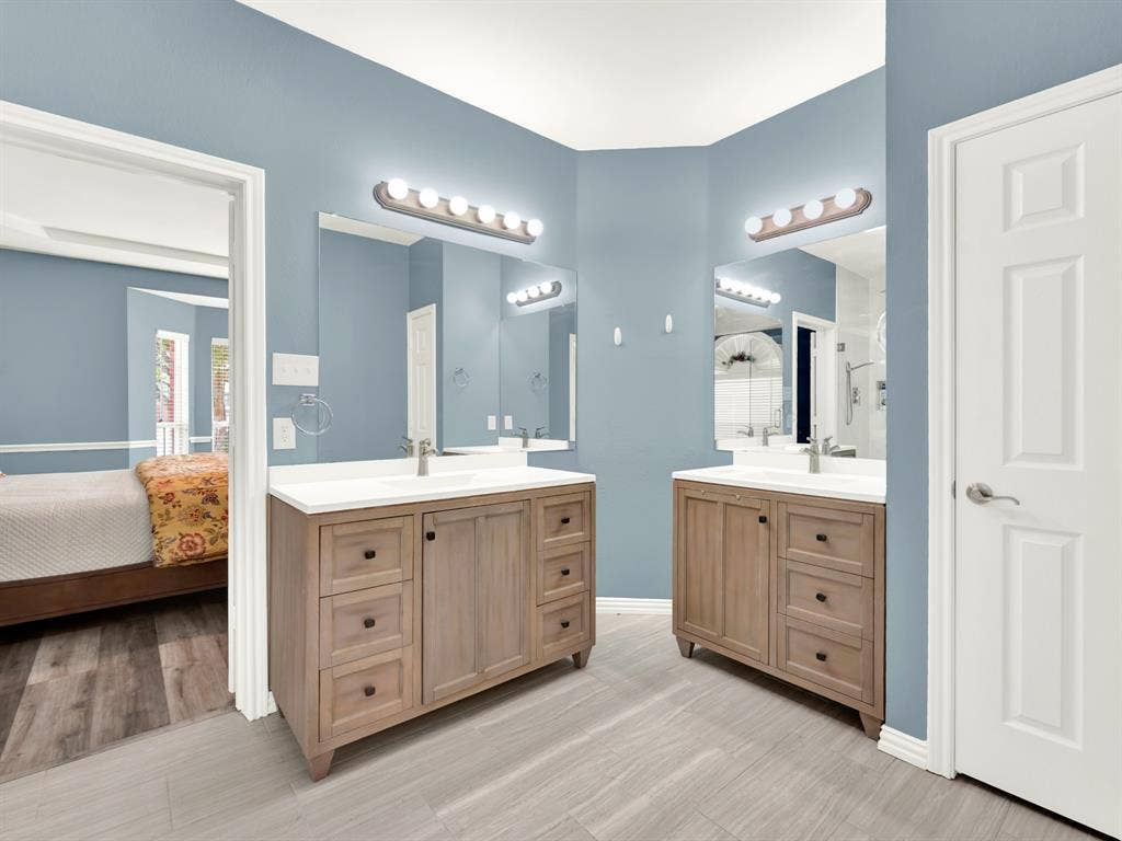 Separate wood vanities with white countertops give each person their own space, while broad mirrors spread light throughout the bathroom. Get ready for an evening out together without competing for counter space.
