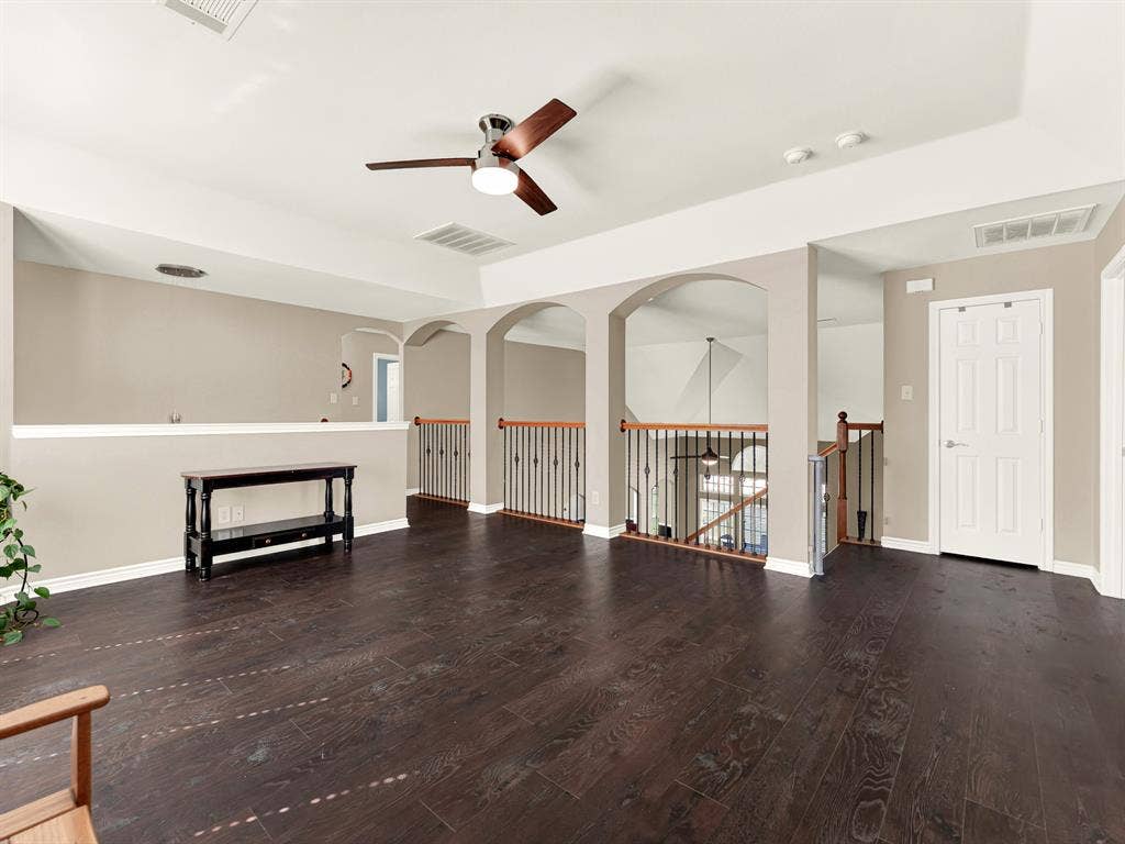 A series of arched overlooks frames views of the living room below, giving the upstairs gathering space an airy, connected feel. Enjoy a casual game of cards while staying within earshot of the household downstairs.