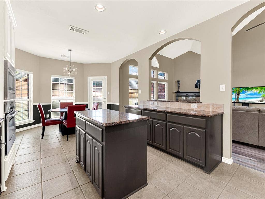 Wide arched openings extend sightlines into the living area, keeping the kitchen connected while giving each space its own character. Set out a few appetizers and enjoy catching up with friends without leaving the conversation.