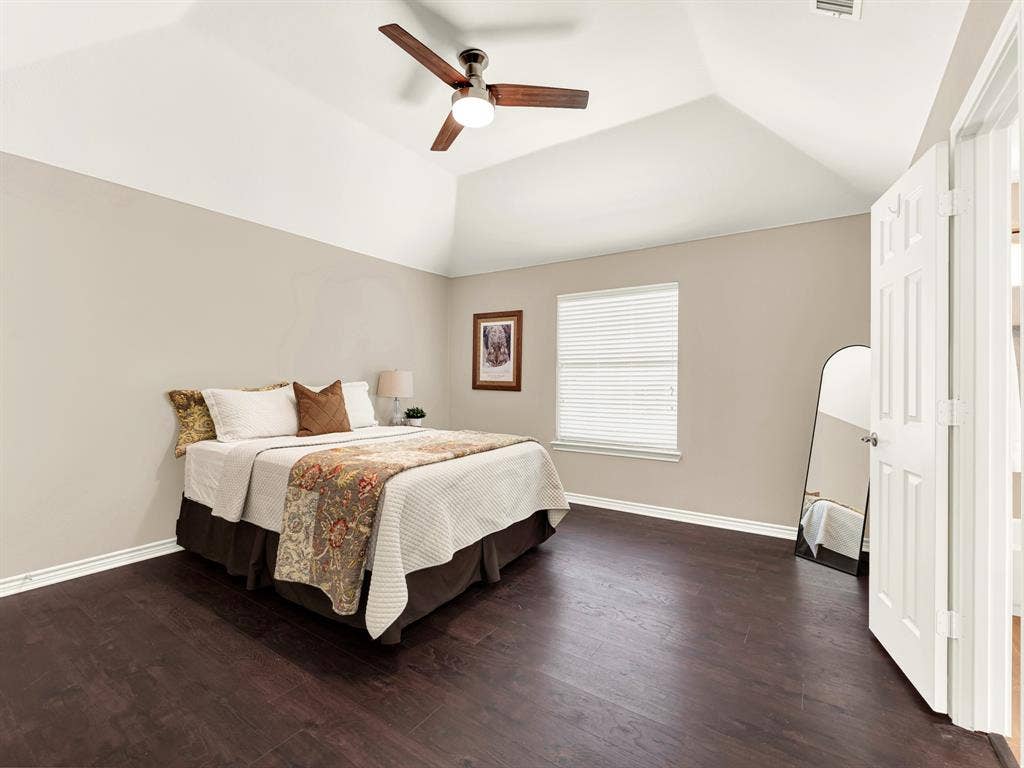 An angular vaulted ceiling lifts this bedroom above its neutral walls, allowing daylight to soften the room’s upper contours. Give visiting family a comfortable place to unpack and unwind after their trip.