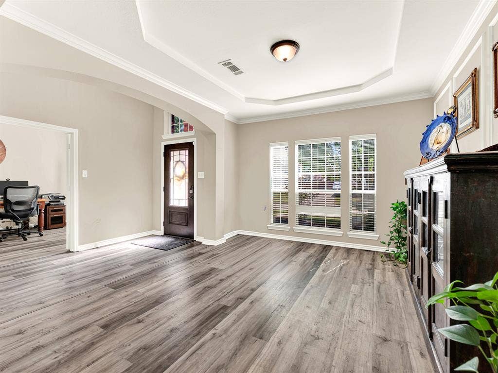 Three tall front windows cast ribbons of sunlight across the floor, giving this flexible living space a bright, easygoing feel. Enjoy an afternoon listening to music while watching the neighborhood beyond the glass.