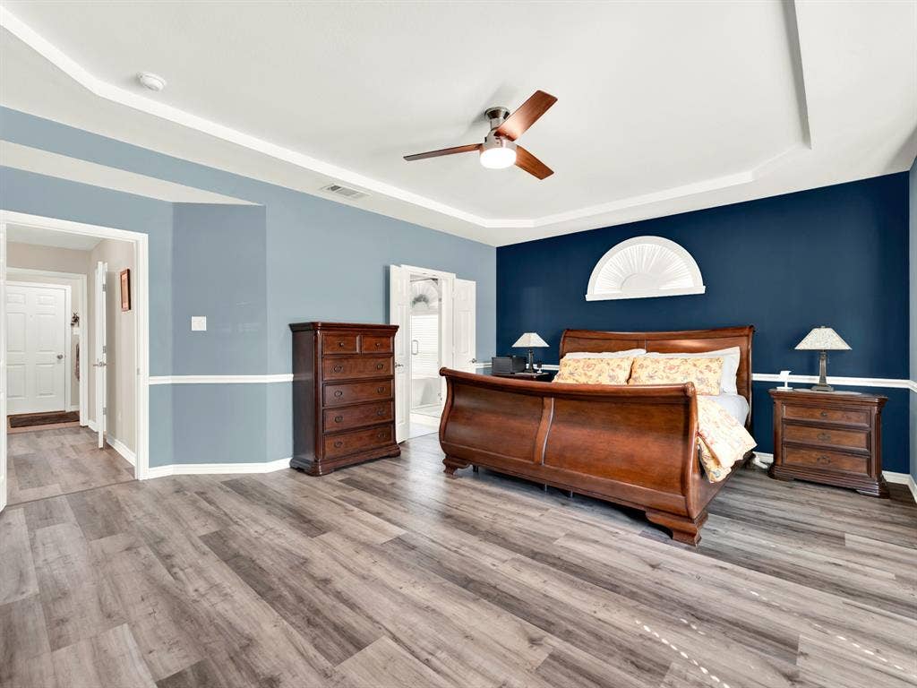 The recessed tray ceiling adds height and dimension, while a navy accent wall gives the sleeping area a cozy sense of enclosure. End the evening with a favorite book and let tomorrow’s plans wait.