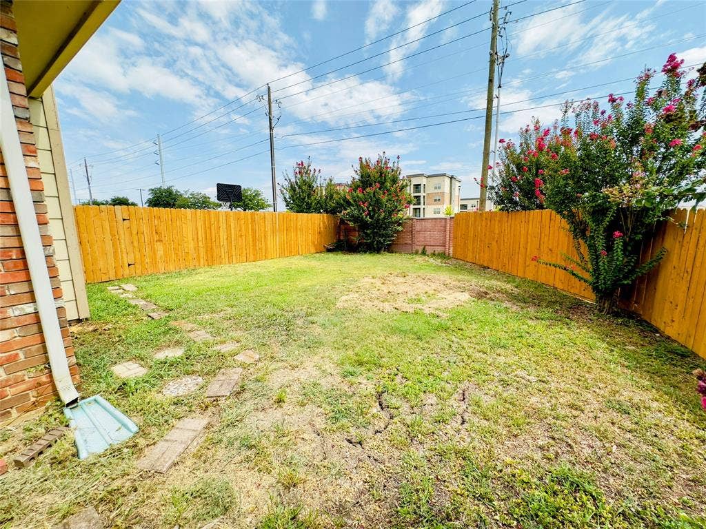 Enclosed yard featuring a wooden fence and existing landscaping