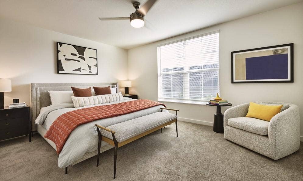 Carpeted bedroom featuring baseboards and ceiling fan