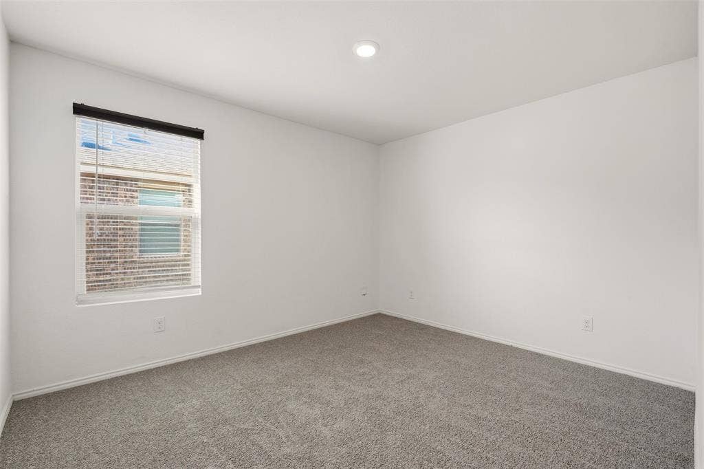 Recessed lighting, neutral wall tones, window with blinds, and gray carpeting