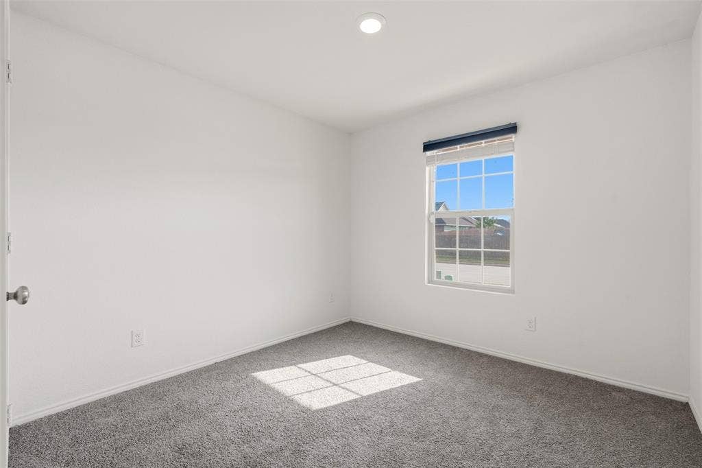 Neutral wall color, recessed ceiling light, window with horizontal blinds, and gray carpet flooring