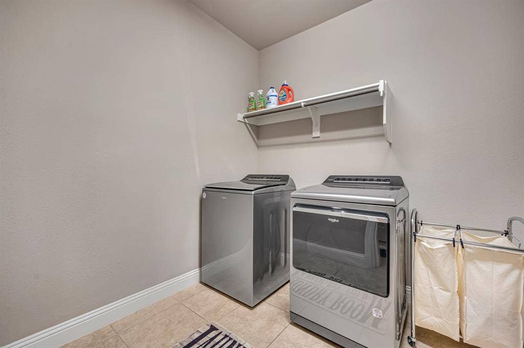 Laundry space featuring tile flooring and built-in wall shelving