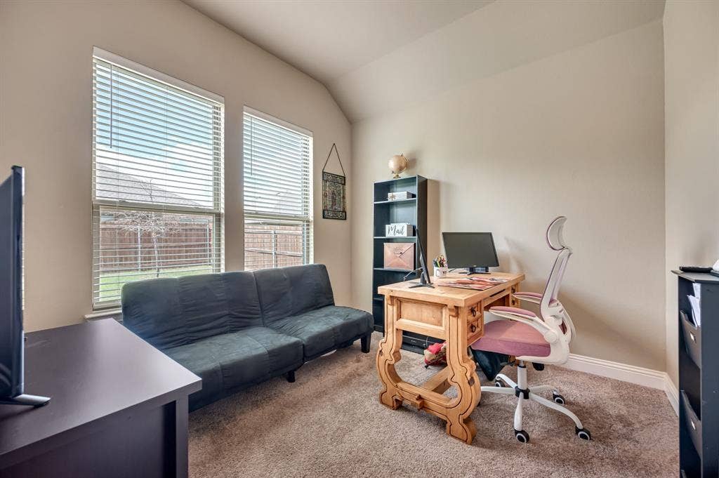 Room featuring neutral wall tones, plush wall-to-wall carpeting, and a vaulted ceiling, illuminated by dual windows with installed horizontal blinds
