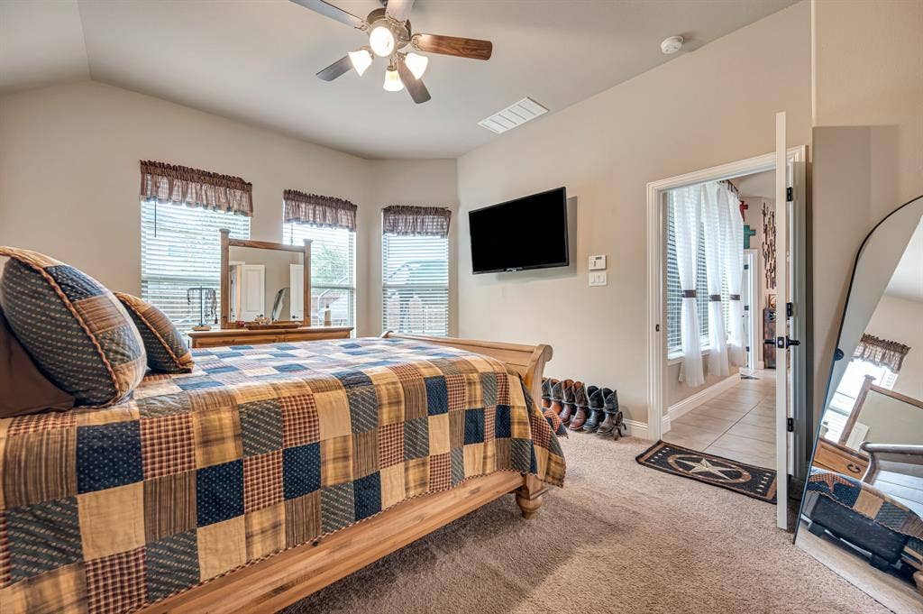 Vaulted ceilings, three-paneled bay window, and a multi-light ceiling fan with integrated light fixture