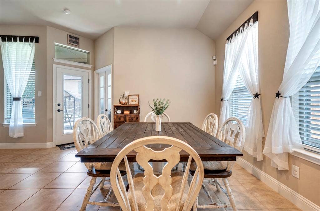 Tile flooring, vaulted ceilings, natural light, transom windows, and an exterior door with glass insert