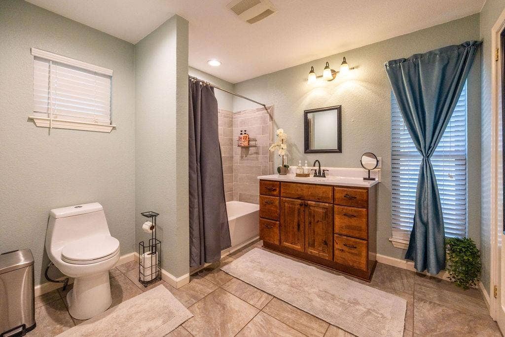 384 Fort Graham Road, Waco, TX 76705 Wood-finish vanity with white countertop, undermount sink, and matte black faucet