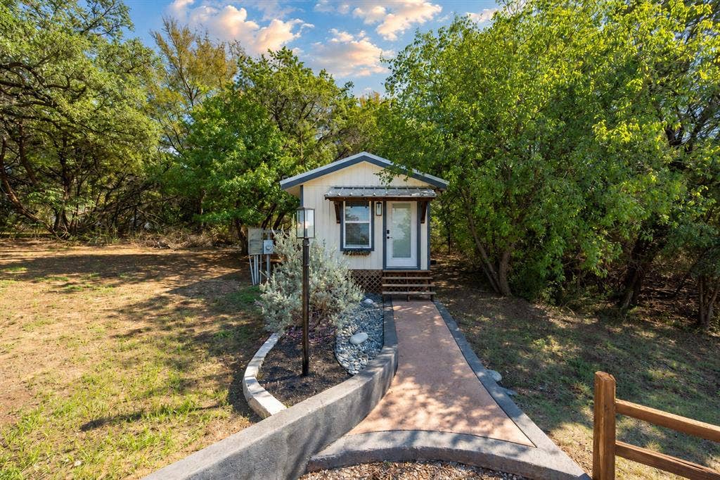 384 Fort Graham Road, Waco, TX 76705 Compact residence featuring a light-colored exterior, covered entry, and wooden steps