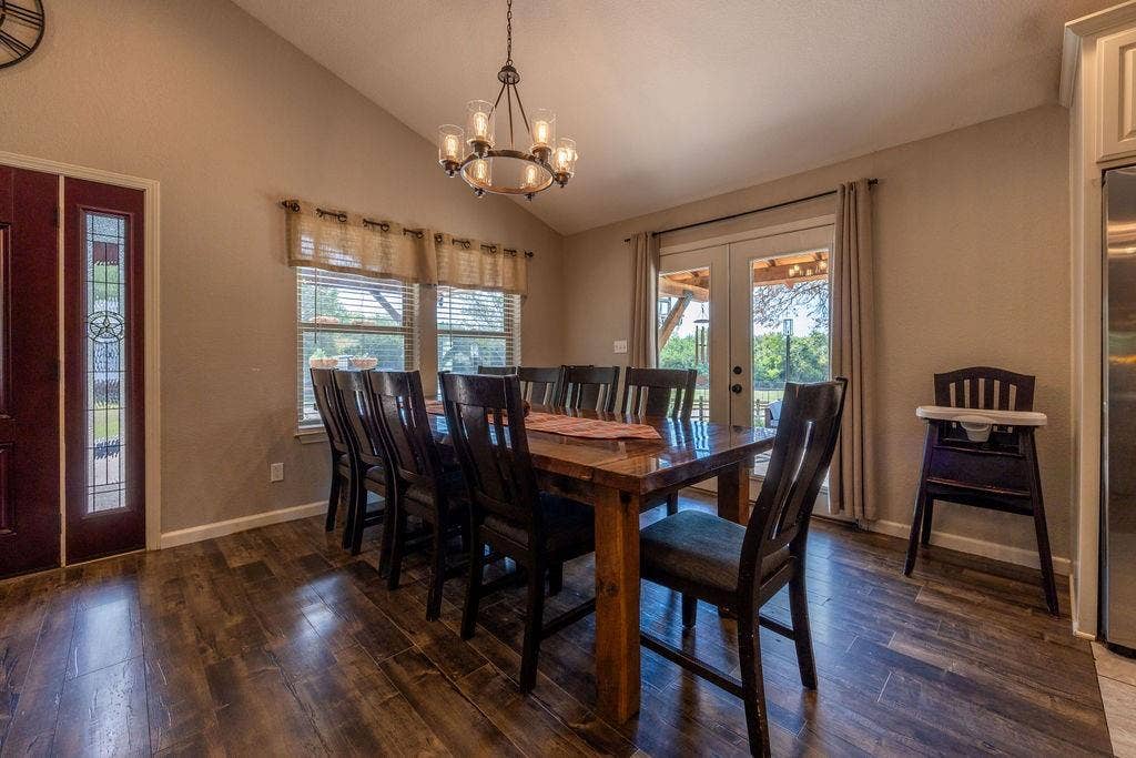 384 Fort Graham Road, Waco, TX 76705 Vaulted ceiling, wood-finish flooring, decorative entryway door with sidelight, double french doors, and a chandelier lighting fixture