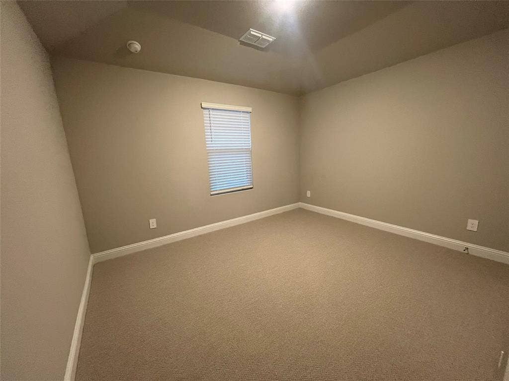 Neutral toned walls with carpet flooring, a window with blinds, and recessed lighting