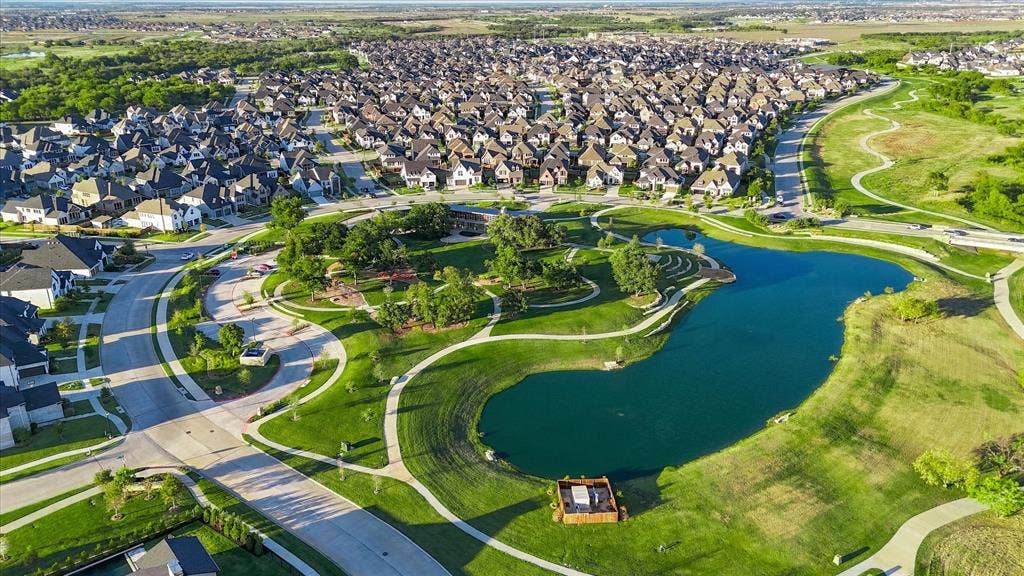 4301 Corabelle Lane, Prosper, TX 75078 Expansive community featuring residential properties, a large central pond, numerous paved walking paths, and extensive green spaces with mature trees