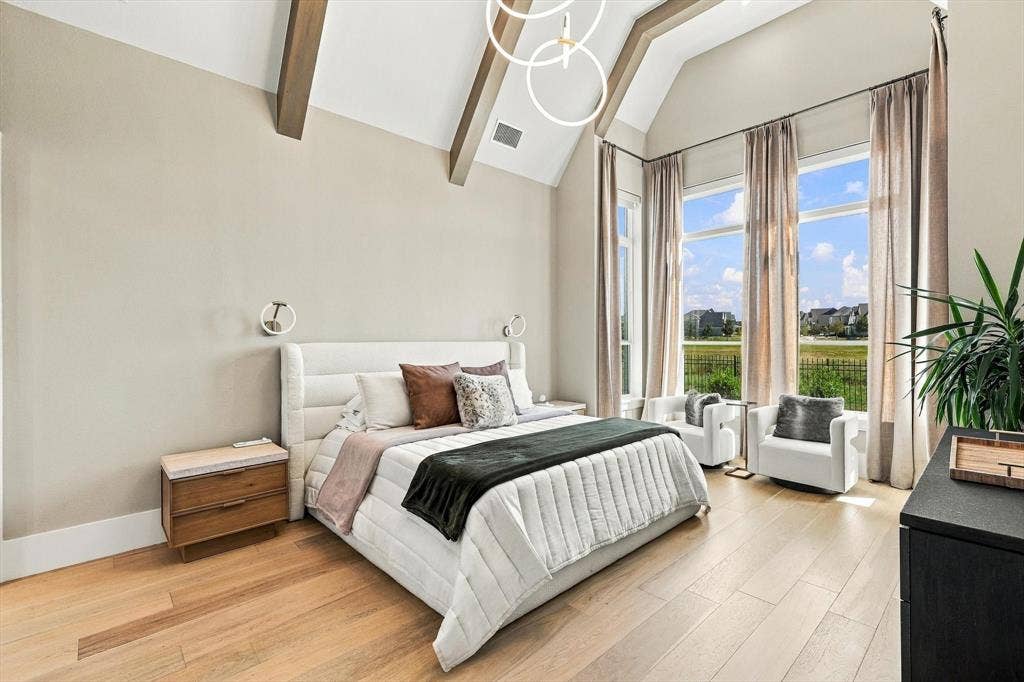 4301 Corabelle Lane, Prosper, TX 75078 Vaulted ceiling with exposed wood beams, wood-finish flooring, three large windows, modern circular pendant lighting, and wall-mounted sconces