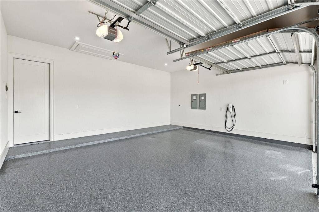 4301 Corabelle Lane, Prosper, TX 75078 Spacious garage featuring a durable epoxy floor, integrated overhead lighting, and an electric vehicle charging station