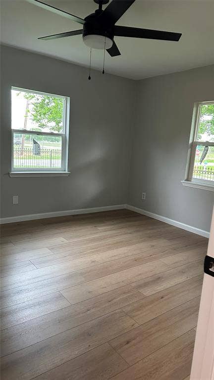 Wood-finish flooring with a neutral paint palette and two windows
