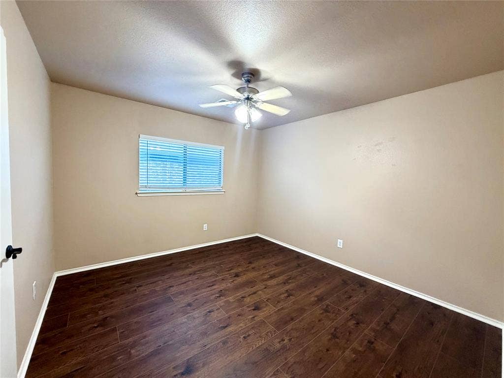 9016 Warren Drive, McKinney, TX 75071 Room featuring wood-finish flooring, neutral wall paint, and a ceiling-mounted light fixture with an integrated fan