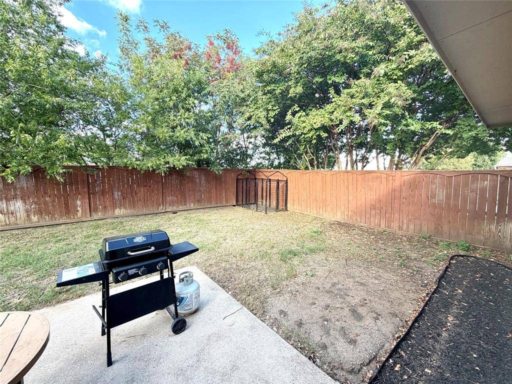 9016 Warren Drive, McKinney, TX 75071 Rear yard featuring a concrete patio, perimeter wood fencing, and mature trees