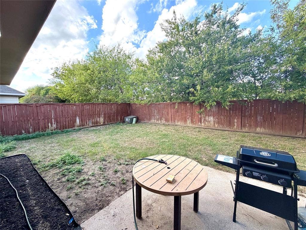 9016 Warren Drive, McKinney, TX 75071 Backyard featuring a concrete patio, a lawn area, and a wood privacy fence
